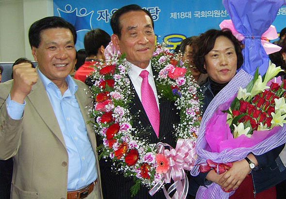 5선 고지에 오른 자유선진당 이용희 당선자가 화환을 목에 두른채 지자들에 둘러싸여 축하인사를 받고 있다. 연합뉴스