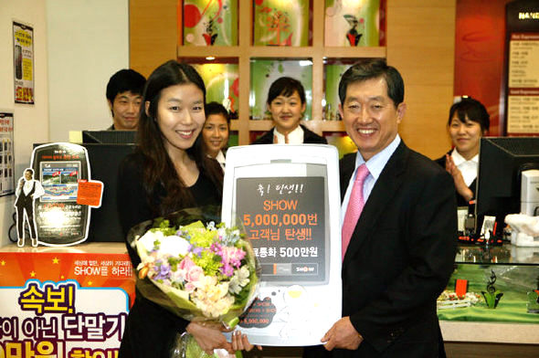 케이티에프(KTF)의 3세대 이동통신 서비스인 ‘쇼’ 가입자가 12일 500만명을 넘었다. 조영주(오른쪽) 케이티에프 사장이 쇼에 500만번째로 가입한 양나들(25·경기도 성남시 분당구)씨에게 500만원어치 무료 통화권을 주고 있다. 케이티에프 제공.