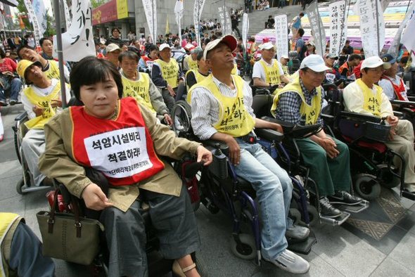 장애인의 날을 맞아 20일 오후 서울 세종문화회관 앞에서 열린 장애인 차별철폐 투쟁결의대회에서 참가자들이 장애인에 대한 따뜻한 관심과 지원을 촉구하고 있다. 연합