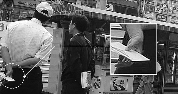 지난 20일 오후 4시께 경기 고양시 주엽동의 한 백화점 앞에서 한 일간지 판촉사원(모자쓴 이)이 뒤춤에 상품권이 담긴 봉투를 들고 있다.  최현준 기자 <A href="mailto:haojune@hani.co.kr">haojune@hani.co.kr</A>