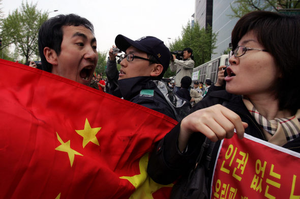 베이징올림픽 성화봉송저지시민행동회원(오른쪽)과 오성기를 든 중국인이 27일 오후 서울 송파구 방이동 올림픽공원 앞에서 성화봉송 행렬이 지나간 뒤 입씨름을 하고 있다. 이종근 기자 root2@hani.co.kr