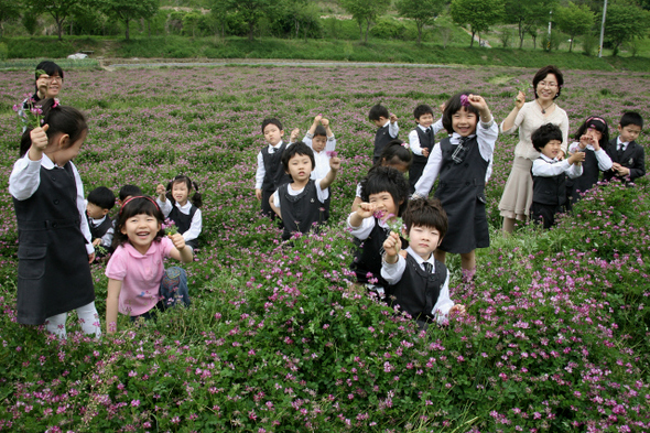 지난 8일 대전시 동구 침산동 ‘자운영 꽃밭’을 찾은 아이들이 분홍빛 꽃이 신기한 듯 웃고 있다. 지난 8일 대전시 동구 침산동 ‘자운영 꽃밭’을 찾은 아이들이 분홍빛 꽃이 신기한 듯 웃고 있다.