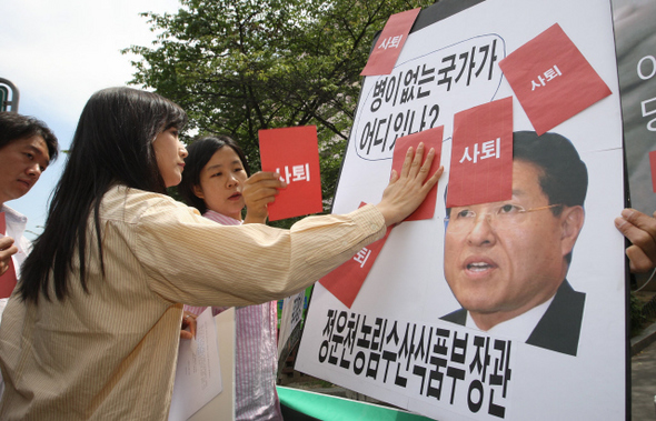 진보신당 당원들이 12일 오전 서울 강남구 개포동 정운천 농림수산식품부 장관 집 앞에서 미국산 쇠고기 수입 개방 조건의 재협상을 촉구하며 정 장관 얼굴 사진 위에 ‘사퇴’가 적힌 붉은 카드를 붙이고 있다.  신소영 기자 viator@hani.co.kr