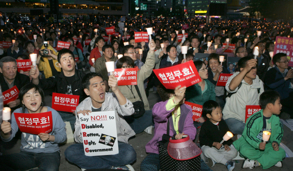 14일 저녁 서울시청 앞 서울광장에서열린 ‘광우병 위험 미국 쇠고기 전면수입 반대 촛불문화제’에 참석한 시민들이 구호가 적힌 손팻말과 촛불을 들고 함성을 지르고 있다. 강재훈기자 khan@hani.co.kr