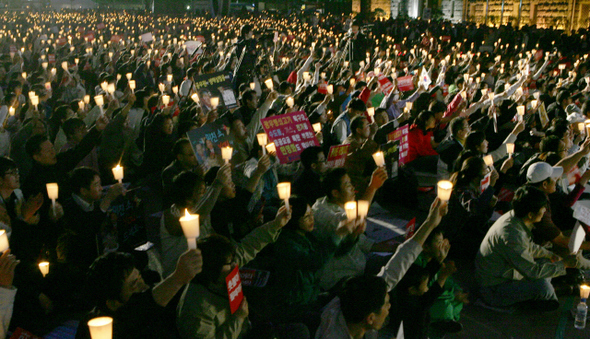 14일 저녁 서울시청 앞 서울광장에서 열린 ‘광우병 위험 미국 쇠고기 전면수입 반대 촛불문화제’에 참석한 시민들이 구호가 적힌 손팻말과 촛불을 들고 함성을 지르고 있다. 강재훈 기자 khan@hani.co.kr