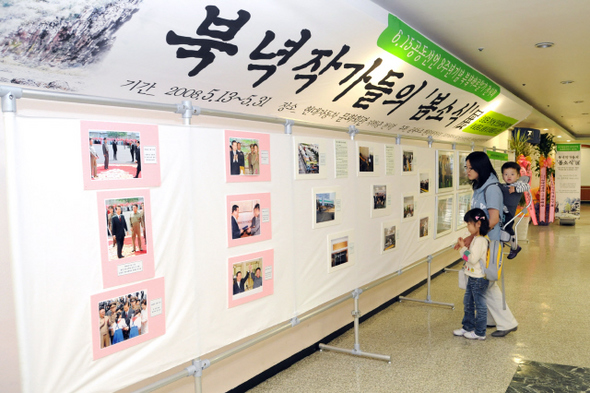 15일 한 주부가 자녀의 손을 잡고 울산 현대자동차 문화회관 전시장에서 열리고 있는 ‘북녘 작가들의 봄 소식’ 전시회 작품을 보고 있다. 15일 한 주부가 자녀의 손을 잡고 울산 현대자동차 문화회관 전시장에서 열리고 있는 ‘북녘 작가들의 봄 소식’ 전시회 작품을 보고 있다.