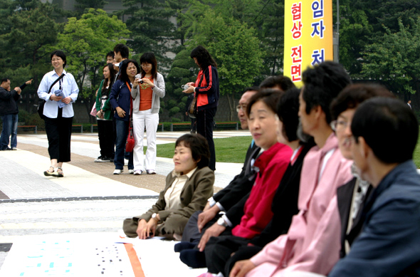 미국산 광우병 위험 쇠고기 수입을 반대하는 야당 국회의원들이 21일 오전 서울 청와대 들머리에서 “추가 협의도 기만”이라며 재협상을 촉구하는 농성을 벌이자, 이곳을 찾은 외국인 관광객들이 신기한 듯 구경하고 있다. 이 농성에는 통합민주당 김태홍·정청래 의원,  민주노동당 천영세 대표·강기갑 의원, 진보신당  노회찬·심상정 상임대표, 무소속 임종인 의원 등이 참여했다.     이종근 기자 root2@hani.co.kr