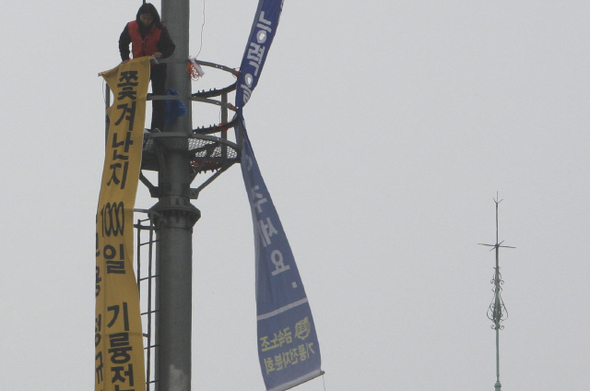 전국금속노조 기륭전자분회 소속 여성 해고 노동자가 26일 서울 구로역 앞 광장에 설치된 철탑 구조물 위에서 이명박 대통령이 비정규직 여성노동자 문제 해결에 직접 나설 것을 촉구하는 고공시위를 벌이고 있다. 이들은 불법 고용을 일삼는 최동열 기륭전자 회장이 이 대통령의 중국 순방에 동행하는 것을 비판하고, 즉시 협상에 나설 것을 요구했다. 신소영 기자 viator@hani.co.kr