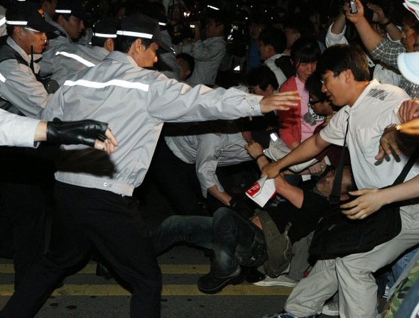  27일 새벽 미국산 쇠고기 수입에 반대하며 종각역 부근에서 경찰이 도로 점거 시위를 벌이던 시위대를 연행하려하고 있다. 연합뉴스