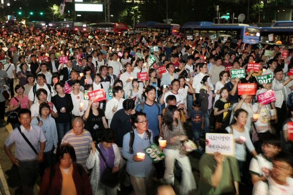 정부가 미국산 쇠고기 수입조건 고시를 발표한 29일 서울 시청 앞 서울광장에서 열린 ‘고시강행! 국민심판! 촛불대행진’에 모인 시민들이 ‘협상무효 고시철회’ ‘이명박 OUT’ 등을 외치며 촛불을 들고 거리로 나서고 있다. 연합뉴스