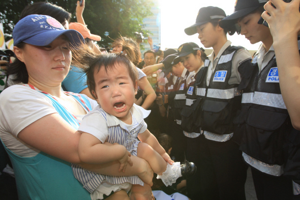 정부가 ‘미국산 쇠고기 수입위생조건 고시’를 발표한 29일 오후 서울 시청 앞 광장에서 고시 철회와 재협상을 요구하며 인도를 따라 행진하던 시민들을 경찰이 막아서자, 이에 놀란 아이가 울음을 터뜨리고 있다. 
 이정아 기자 <A href="mailto:leej@hani.co.kr">leej@hani.co.kr</A>