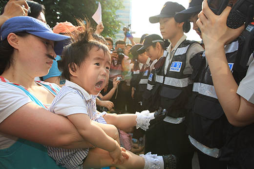 정부가 ‘미국산 쇠고기 수입위생조건 고시’를 발표한 29일 오후 서울 시청광장 앞에서 고시 철회와 재협상을 요구하며 인도를 따라 행진하던 시민들을 경찰이 막아서자 놀란 아기가 울음을 터뜨리고 있다. 이정아 기자 leej@hani.co.kr