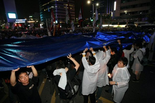 2일 까지 서울 광화문 사거리에서 계속된 미국산 쇠고기 수입반대 촛불 문화제에서 경찰이 살수차량을 준비하자 시위대가 대형 천막을 펼치고 있다. (서울=연합뉴스)