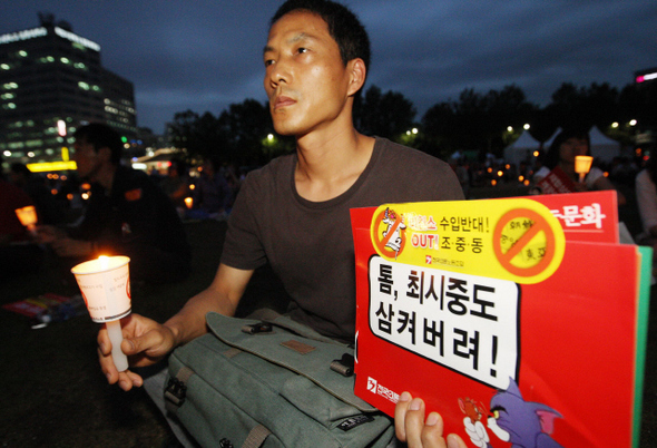 17일 저녁 서울시청 앞 촛불집회에 참가한 한 시민이 정부의 언론장악 움직임과 조·중·동 등 보수언론의 보도를 비판하는 내용의 손팻말을 들고 있다. 신소영 기자 <A href="mailto:viator@hani.co.kr">viator@hani.co.kr</A>