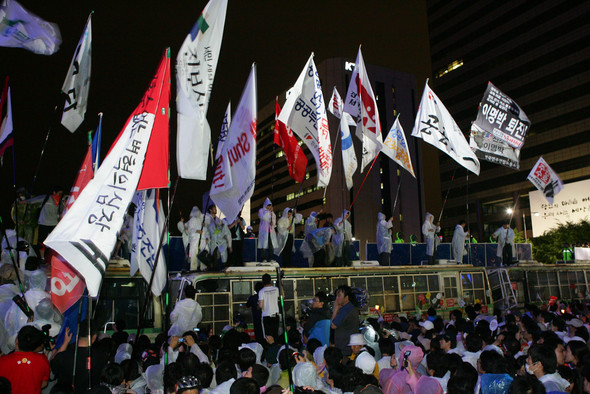 광화문사거리에 모인 시민들이 깃발을 들고 경찰 차벽 위에 올라가 “이명박은 물러가라” “쇠고기 재협상하라” 등의 구호를 외치고 있다. 강창광 기자 chang@hani.co.kr