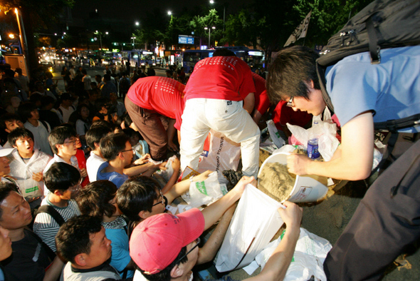 미국산 쇠고기 수입 재협상을 촉구하는 촛불문화제에 참가한 시민들이 21일 밤 남영역 인근에서 모래를 광화문으로 가져가려고 포대에 담고 있다. 강창광 기자 chang@hani.co.kr