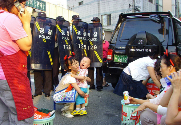 지난 20일 오후 쇠고기 전면 재협상을 촉구하는 거리행진을 벌이던 주부들을 경찰이 가로막자 놀란 아이가 울음을 터트리고 있다.