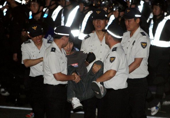 22일 오후 ‘미국산 쇠고기 수입 반대 촛불문화제‘에 참가한 한 시민이 광화문 사거리에서 시위 도중 경찰에 연행되고 있다. (서울=연합뉴스)