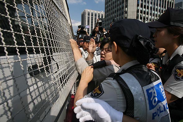 미국산 쇠고기의 수입위생조건 장관 고시 강행 철회를 촉구하며 지난 6월25일 오후 서울 경복궁역 인근에서 기습시위를 벌이던 시민들이 경찰에 연행되자 전경차를 둘러싼 채 시민들이 항의하고 있다. 김진수 기자 jsk@hani.co.kr