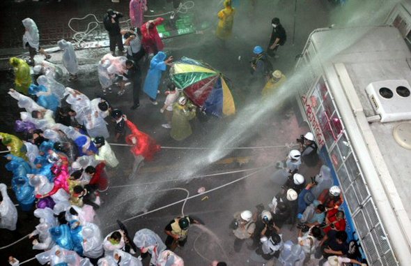 물대포 쏘는 경찰과 저항하는 시위대 … 미국산 수입위생조건 고시가 관보에 게재된 26일 저녁 미국산 쇠고기 수입 반대 거리시위에 참가한 시위대가 광화문 인근 골목길로 청와대 진출을 시도하자 경찰이 물대포를 발사하고 있다 (서울=연합뉴스)