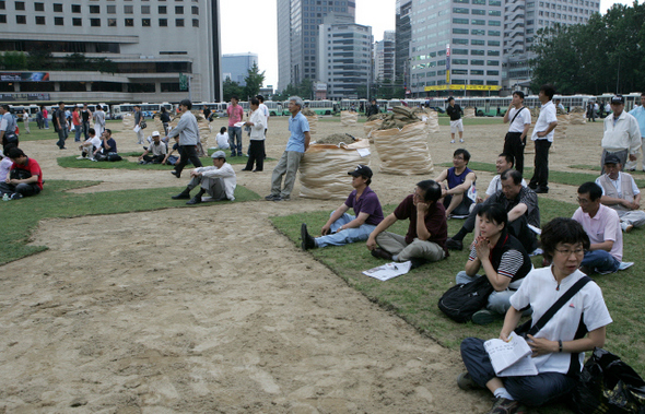 지난달 30일 천주교정의구현 사제단의 시국 미사가 열리기 전 서울광장에 모인 시민들이 잔디가 뽑히지 않은 곳에 삼삼오오 앉아 있다.탁기형 선임기자 <A href="mailto:khtak@hani.co.kr">khtak@hani.co.kr</A>