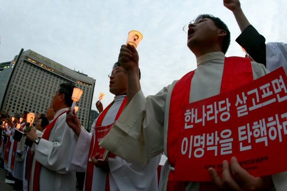 정부의 미국산 쇠고기 수입고시와 재개에 반대해 3일 오후 서울 시청광장에서 시기도회를 가진 한국기독교협의회 소속 목회자들이 촛불을 들고 정부의 쇠고기 고시철회 재협상을 기도하고 있다. 연합