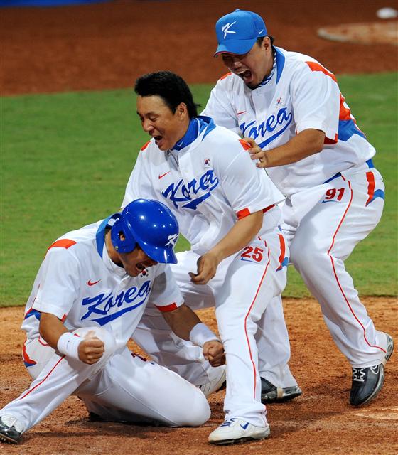 한국 올림픽 야구 대표팀의 이택근(왼쪽)이 13일 열린 미국과 경기 9회말에 이종욱의 뜬공으로 홈을 밟으며 역전승을 거두자 이승엽과 송승준이 뛰어나와 함께 기뻐하고 있다. 