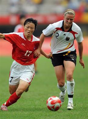 북한 김영애(왼쪽)가 12일 톈진 올림픽 스타디움에서 열린 여자 축구 F조 독일전에서 수비수를 따돌리며 돌파를 시도하고 있다.  베이징/신화 연합