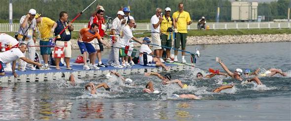 베이징올림픽에서 신설된 여자 수영 10km 마라톤에 출전한 선수들이 경기 중간에 코치로부터 음료수와 먹거리를 건네받고 있다.  베이징/AP 연합