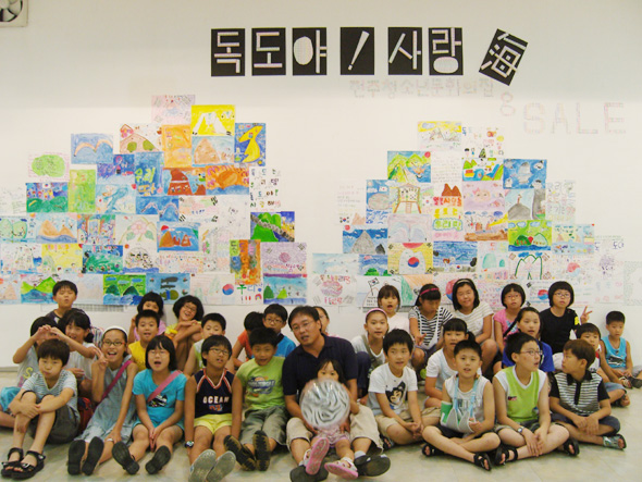 광복절인 지난 15일부터 일주일간 열린 ‘독도야, 사랑해’ 그림 전시회에 작품을 낸 학생들. 앞줄 가운데가 학생들에게 그림을 지도해준 이정웅 화가이다.
  전주 청소년문화의집 제공
