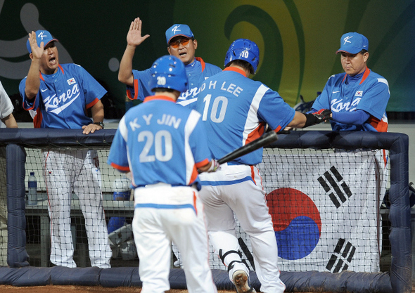 김경문 한국 야구대표팀 감독(오른쪽)이 16일 베이징 우커송 야구장에서 열린 일본전에서 2점 동점포를 친 이대호와 손을 마주치고 있다. 
 베이징/올림픽사진공동취재단