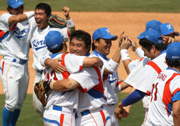 <b>‘여름의 전설’ 1승 남았다</b>    이승엽 선수(왼쪽에서 5번째) 등 한국 야구대표팀 선수들이 22일 일본 대표팀을 꺾고 올림픽 결승 진출을 확정한 순간 마운드로 몰려나와 얼싸안으며 기뻐하고 있다. 베이징/올림픽사진공동취재단