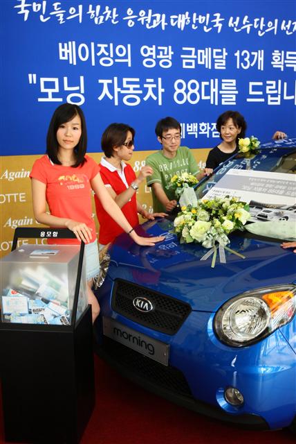  25일 서울 소공동 롯데백화점에서 직원들이  베이징올림픽 관련 경품행사 홍보를 하고 있다. 롯데백화점은 이번 올림픽에서 한국 선수들이 사상 최다 금메달을 따냄에 따라, 애초 고객들에게 약속한 경차 88대 모두를 고객 추첨을 통해 주기로 했다.   연합뉴스