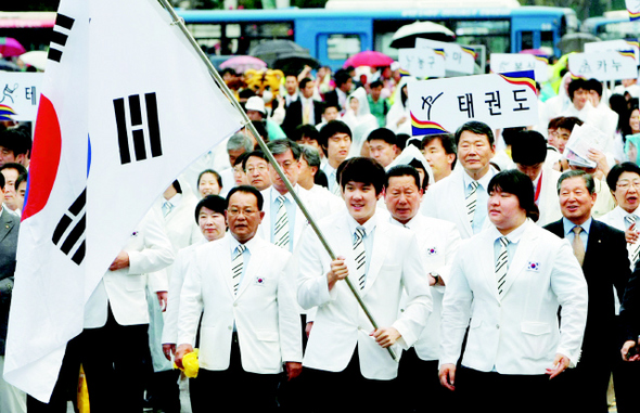 태극기를 든 박태환을 선두로 장미란(오른쪽) 등 베이징 올림픽 한국 선수단이 25일 저녁 서울 광화문에서 시청앞 서울광장을 향해 도보 행진을 하고 있다. 박종식 기자 <A href="mailto:anaki@hani.co.kr">anaki@hani.co.kr</A>