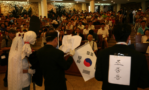 서울 프란치스코 교육회관에서 지난달 30일 열린 ‘언론소비자주권 국민캠페인’ 창립총회에서 참가자들이 이명박 대통령(가운데)이 주례를 보는 가운데 검찰(신부)과 조중동(신랑)이 결혼식을 하는 행위극을 선보이고 있다. 이 대통령이 베이징 올림픽에서 태극기를 거꾸로 들며 응원한 모습을 풍자해 태극기를 거꾸로 그렸다.
 이종근 기자 root2@hani.co.kr