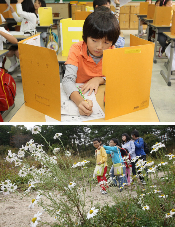 초등학교 3학년생을 대상으로 한 국가수준 기초학력 진단평가가 실시된 8일 오전, 서울 미근동 미동초등학교에서 한  어린이가 진단평가 2교시 쓰기 시험지를 받아 이름을 적고 있다(위 사진). 시험을 거부하고 경기도 포천시 평강식물원에 생태체험학습을 나선 학생들이 눈을 감고 줄을 지어 숲길을 걷고 있다. 학생을 보호하기 위해 얼굴을 가렸다.  포천/김진수 기자, 신소영 기자 jsk@hani.co.kr