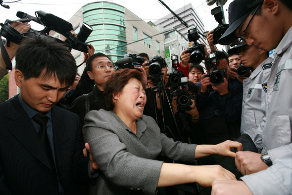 23일 오전 서울 논현동 ㄷ고시원에서 방화·살인 사건을 저지른 정아무개(31)씨에 대한 현장검증이 벌어졌다. 희생자 유족들이 범인 얼굴 공개와 장례·보상 대책을 촉구하며 울부짖고 있다.  이종근 기자 <A href="mailto:root2@hani.co.kr">root2@hani.co.kr</A>