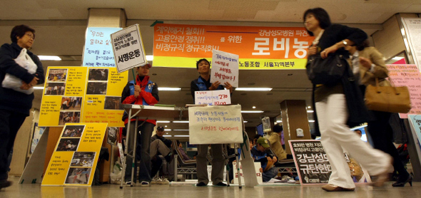 서울 강남성모병원 비정규직 노동자들이 30일 오전 서초동 병원 로비에서 고용 안정과 정규직화를 촉구하는 손팻말을 든 채 농성을 하고 있다.  박종식 기자 anaki@hani.co.kr