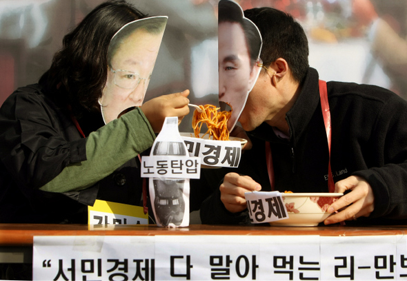 민주노총 간부 및 산별노조 위원장 등이 3일 오전 청와대 들머리인 서울 종로 청운동 주민센터 앞에서 ‘경제위기 민생파탄 이명박 정부 규탄 및 신자유주의 시장화정책 폐기 촉구’ 기자회견을 열어, 현 정부가 서민경제를 파탄으로 몰아가고 있다고 풍자하는 행위극을 펼치고 있다.  이종근 기자 root2@hani.co.kr