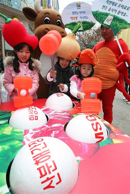  대상(주)이 자연조미료의 안정성과 화학첨가물의 위험성을 알리기 위해 1일 오전 서울 명동에서 청정원 ‘맛선생’ 출시 1주년 기념 ‘화학첨가물 잡기’행사를 열었다. 어린이들이 각종 화학첨가물의 이름이 적힌 공을 망치로 때리고 있다.   연합뉴스