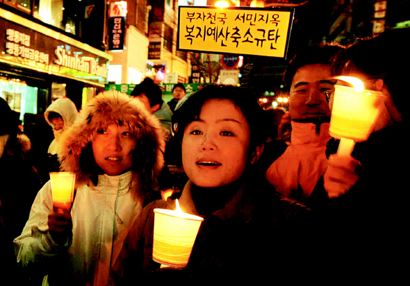 ‘경제파탄 민주파괴 심판 국민대회’가 열린 지난 6일 저녁 서울 명동거리에서 참가자들이 ‘복지예산 축소규탄’ 등의 손팻말을 들고 촛불 집회를 열고 있다. 
 박종식 기자 anaki@hani.co.kr