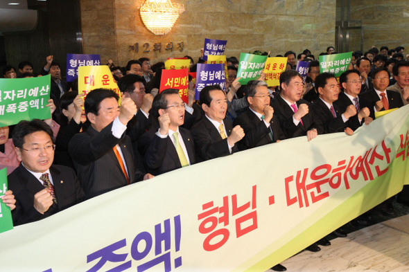 <b>한밤 ‘전운’ 감도는 국회</b> 정세균 민주당 대표와 소속 의원,당직자들이 12일 밤 국회 예결위원회 회의장 앞에서 일자리 예산확대와 대운하 예산 삭감 등을 촉구하며 규탄구호를 외치고 있다. 강창광 기자 chang@hani.co.kr
