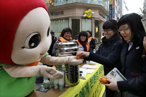 <b>위탁급식은 싫어요</b> 친환경급식을 위한 서울운동본부 회원들이 16일 낮 서울 명동에서 시민들에게 위탁급식의 문제점을 알리고 직영급식 원칙을 훼손하는 학교급식법 개정안에 반대하는 서명운동을 받으며 친환경농법으로 재배된 귤을 나누어주고 있다. 이정아 기자 leej@hani.co.kr