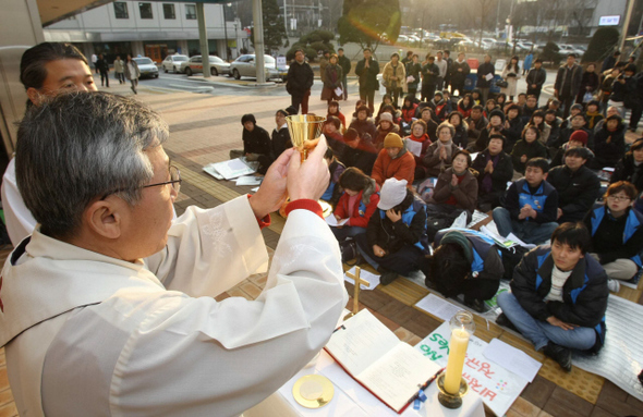 비정규직 노동자들과 함께하는 성탄미사가 열린 서울 반포동 강남성모병원 앞에서 24일 오후 호인수 신부(맨 왼쪽)가 미사를 집전하고 있다. 이정아 기자 leej@hani.co.kr