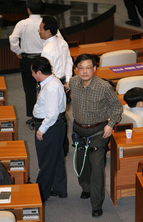 문학진 의원(맨 앞) 등 민주당 의원들이 31일 새벽 농성 중인 국회 본회의장에서 강제해산에 대비해 서로 묶을 ‘인간사슬’로 쓸 암벽등반용 줄을 바지춤에 찬 채 걸어가고 있다.
 강창광 기자 chang@hani.co.kr