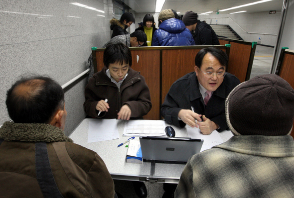 노숙자들에게 무료 진료를 해 주는 주영수 한림대 의대 교수(앞줄 오른쪽 안경 쓴 이)가 지난달 26일 저녁, 서울역 지하보도에 설치한 간이 진료소에서 자원봉사자들과 함께 노숙자들을 진료하고 있다. 
 김명진 기자 littleprince@hani.co.kr