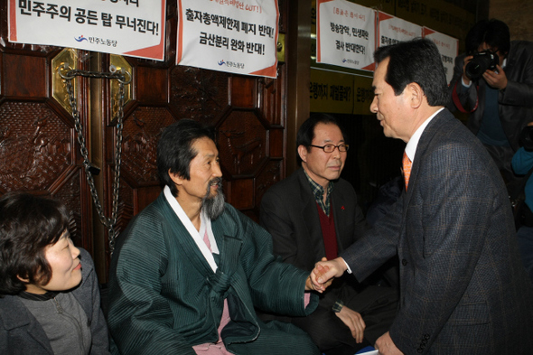 정세균 민주당 대표가 6일 오전 국회 본회의장 들머리에서 농성을 계속하고 있는 강기갑 민주노동당 대표의 손을 잡은 채 민주당이 본회의장 농성을 푼 이유를 설명하며 위로의 말을 건네고 있다. 박종식 기자 <A href="mailto:anaki@hani.co.kr">anaki@hani.co.kr</A>