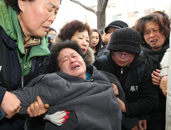 경찰이 농성중이던 용산 철거민들을 진압하는 과정에서 철거민 5명과 경찰 1명 등 6명이 사망하고 십여명이 부상하는 참사가 발생한지 이틀이 지났다. 22일 오전 서울 용산 사고 현장에 마련된 희생자 분향소를 찾은 조문객들이 오열하고 있다. 연합뉴스