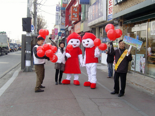대한적십자사 전북혈액원 직원들이 지난 21일 익산 헌혈의집 앞에서 시민들에게 ‘헌혈사랑’이 새겨진 빨간풍선을 나눠주는 모습.  적십자사 전북혈액원 제공