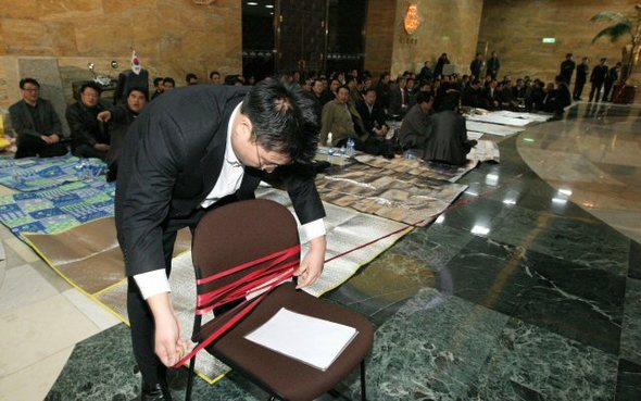 한나라당 사무처 직원들이 1일 국회 본회의장 앞에서 점거농성을 벌이는 의원들 앞에 줄을 치고 있다. 연합뉴스